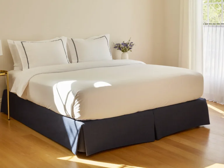 A freshly made bed in a bright, prepared bedroom